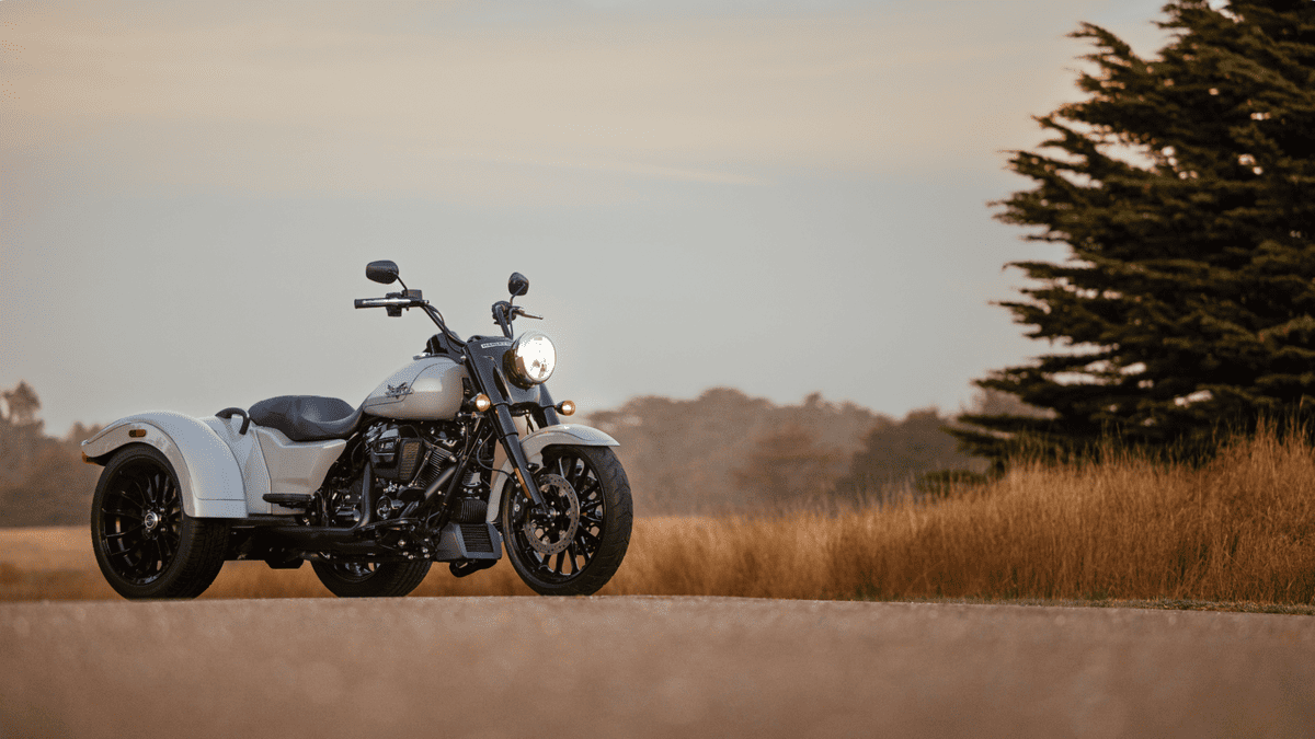 The 2025 Harley-Davidson® Freewheeler® trike stands ready on a country road near Deer Park, TX—classic three-wheel freedom.
