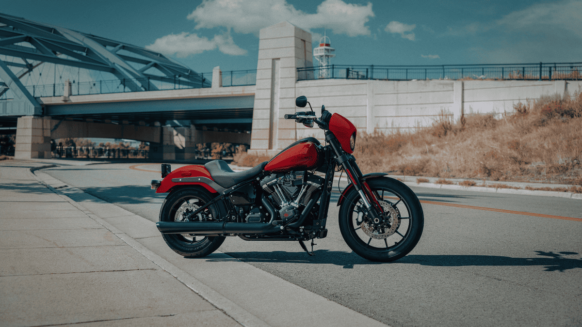 2025 Harley-Davidson® Low Rider® S in red parked near a bridge in Deer Park, TX, built for aggressive performance and sleek urban style.