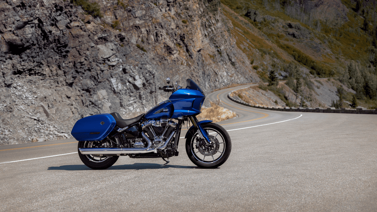 2025 Harley-Davidson® Low Rider® ST parked on winding mountain road near Friendswood, TX, highlighting its bold West Coast styling and performance stance.