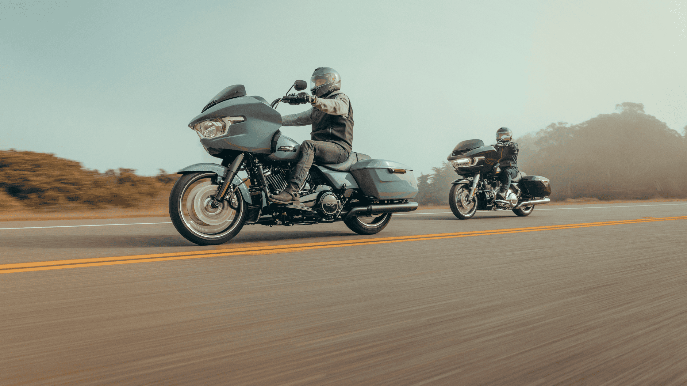  Two riders on 2025 Harley-Davidson® Road Glide® motorcycles cruising on a road near Friendswood, TX.