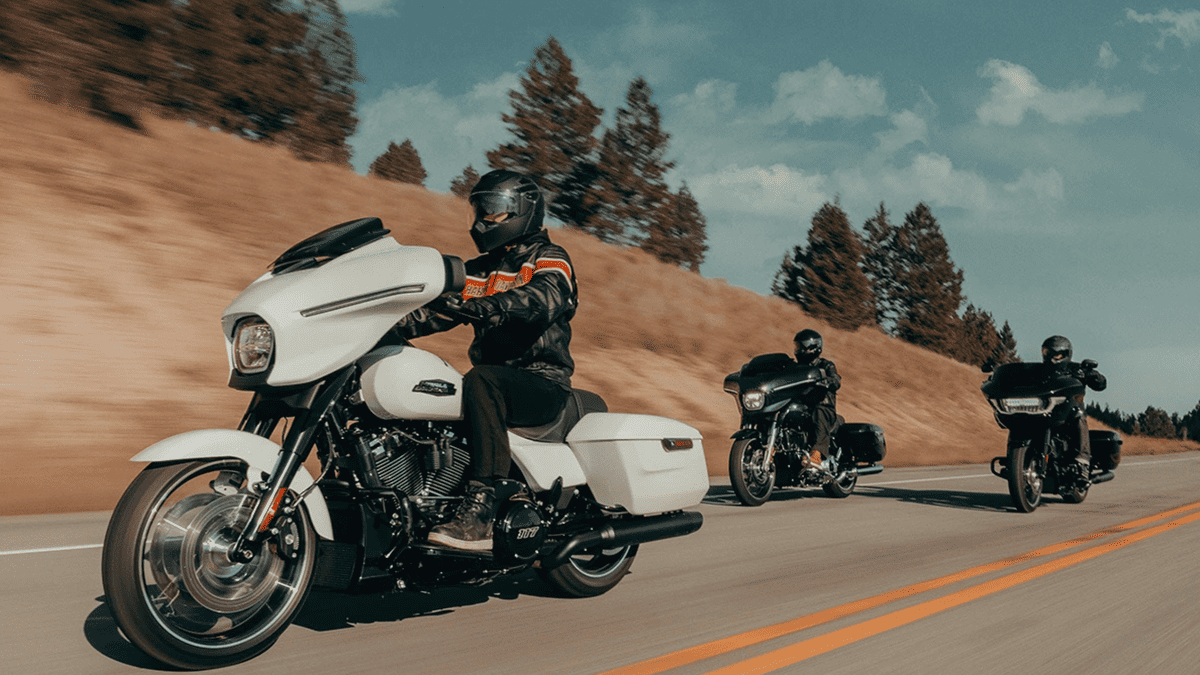 2025 Harley-Davidson® Street Glide® leading a highway pack near Deer Park, TX, showcasing classic touring performance and sleek white finish.